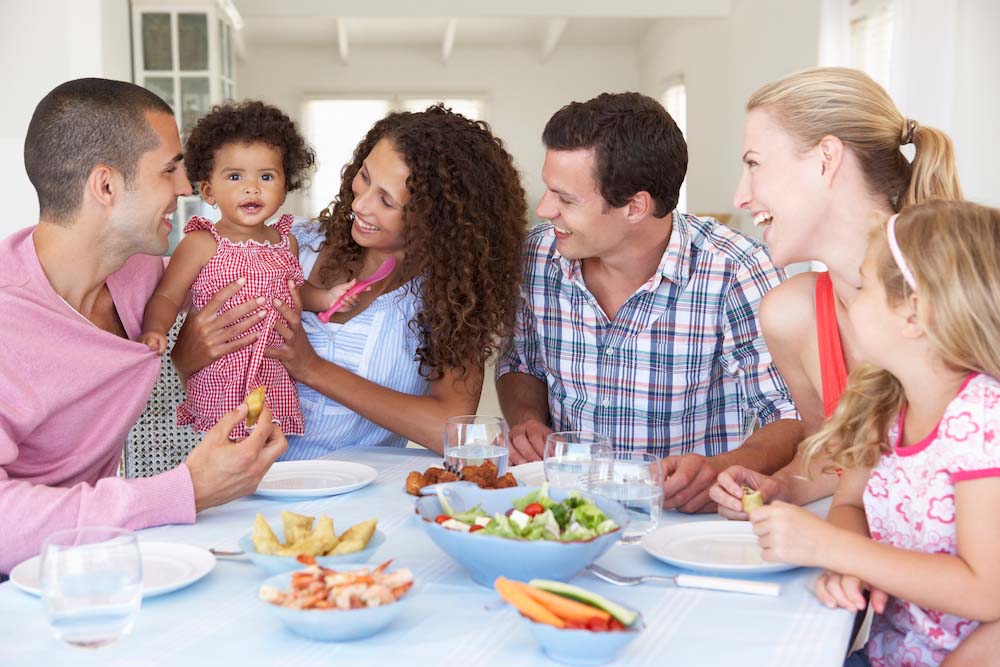Family around table smiling at a baby